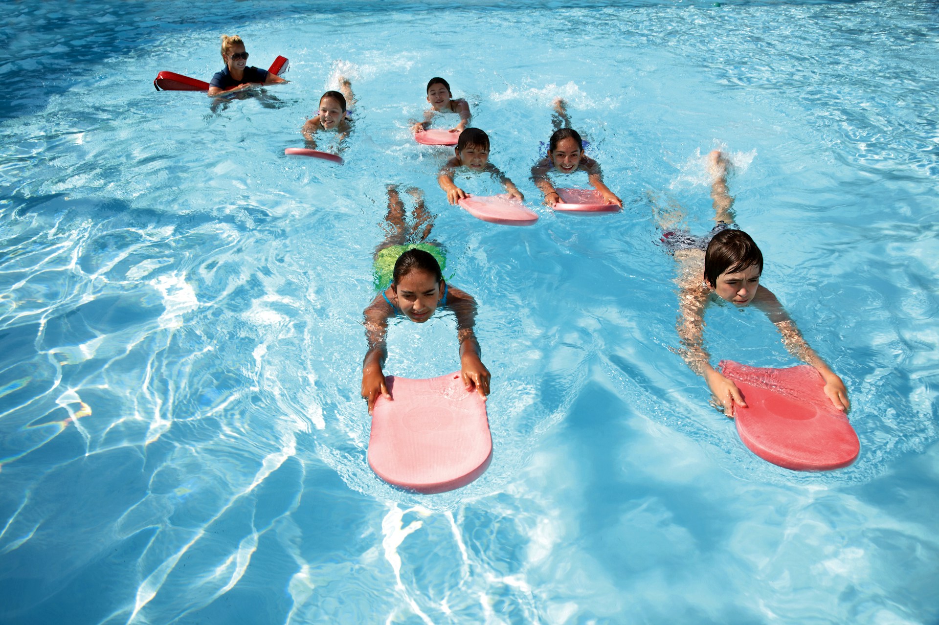 Kids swimming with kickboards during practice